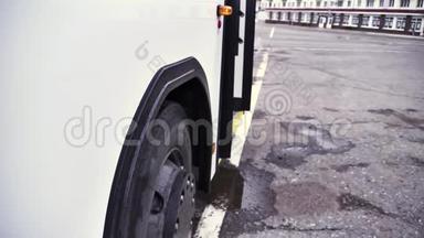 在<strong>灰色</strong>沥青背景下，白色巴士的侧视图与开门和巴士轮。 <strong>场景</strong>。 关闭客车